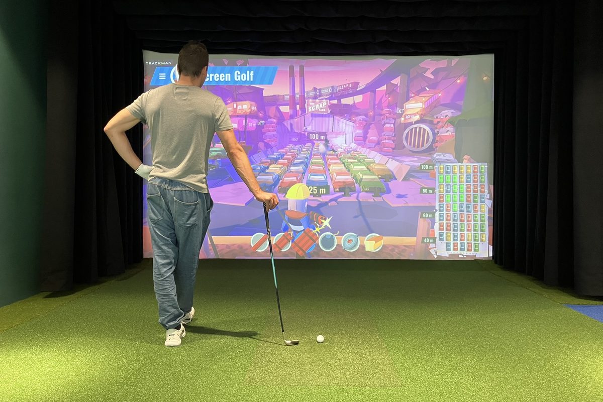 Gracz przy grze Scrap Yard na symulatorze golfowym Screen Golf
